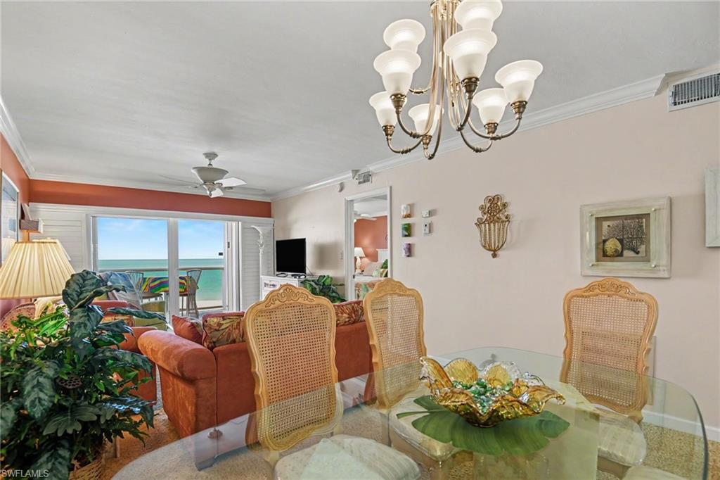 DINING AREA WITH FANTASTIC GULF VIEWS.  ENTRANCE TO PRIMARY SUITE IS SHOWN MIDDLE REAR.  CROWN MOLDING THROUGHOUT UNIT.