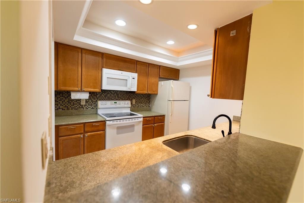 Modern kitchen with cabinets recessed ceiling lights and granite