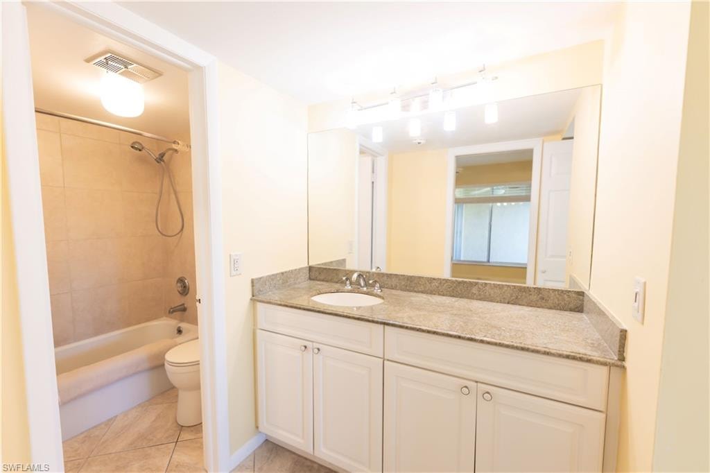Bathroom featuring vanity, shower / tub combination, and light tile patterned floors