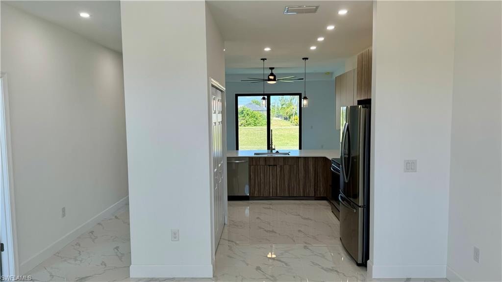 Kitchen with ceiling fan, stainless steel appliances, sink, and light tile floors
