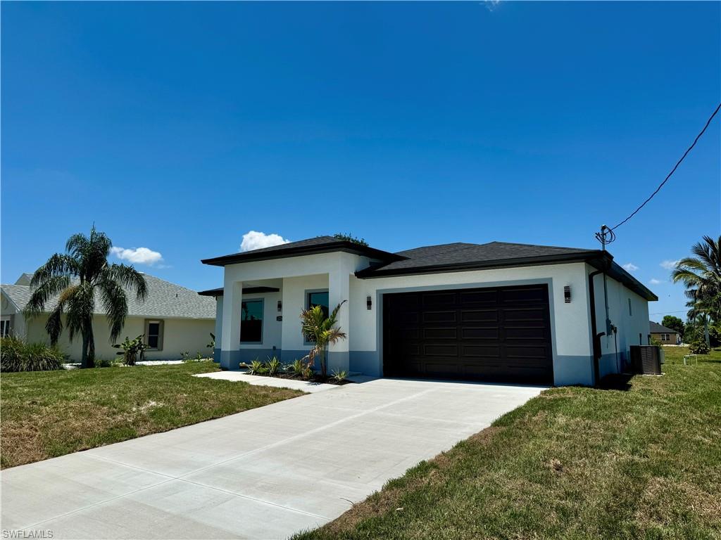 View of front of property with a garage, a front yard, and central air condition unit