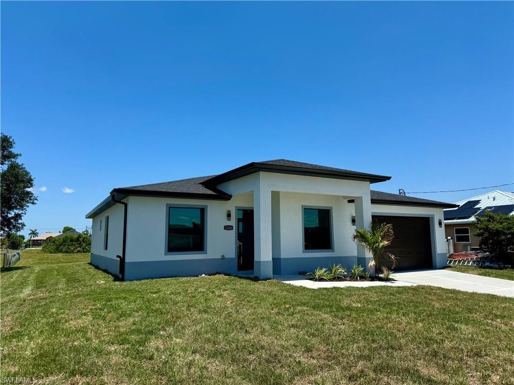 View of front of house with a garage and a front yard