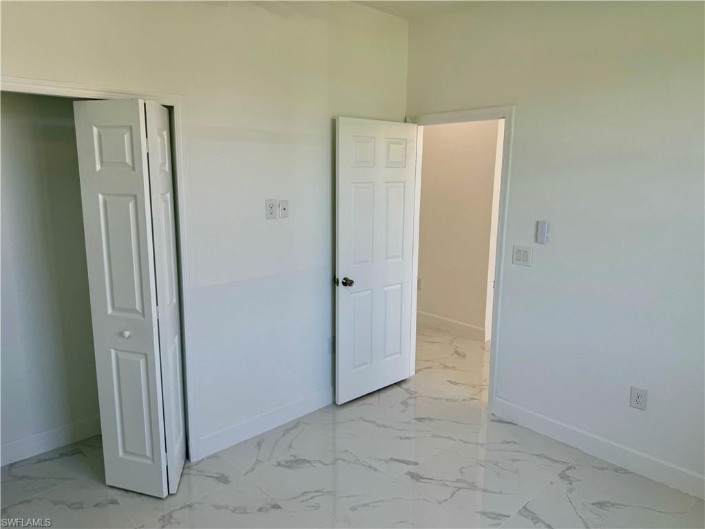 Unfurnished bedroom featuring a closet and light tile floors