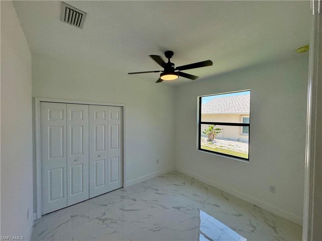 Unfurnished bedroom with a closet, ceiling fan, and tile floors