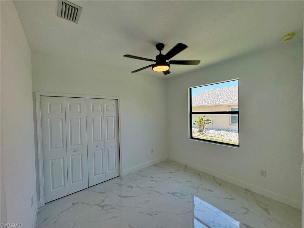 Unfurnished bedroom featuring tile floors, a closet, and ceiling fan