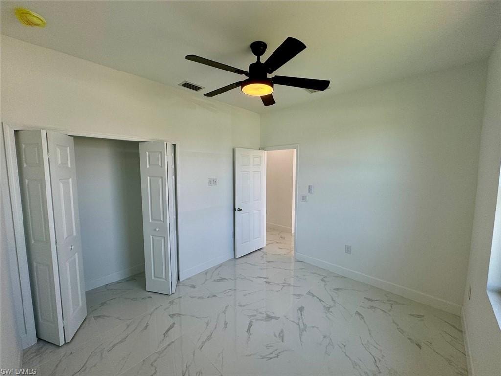 Unfurnished bedroom featuring ceiling fan, a closet, and light tile flooring
