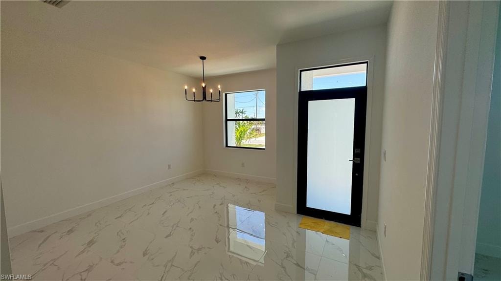 Tiled entryway with a chandelier