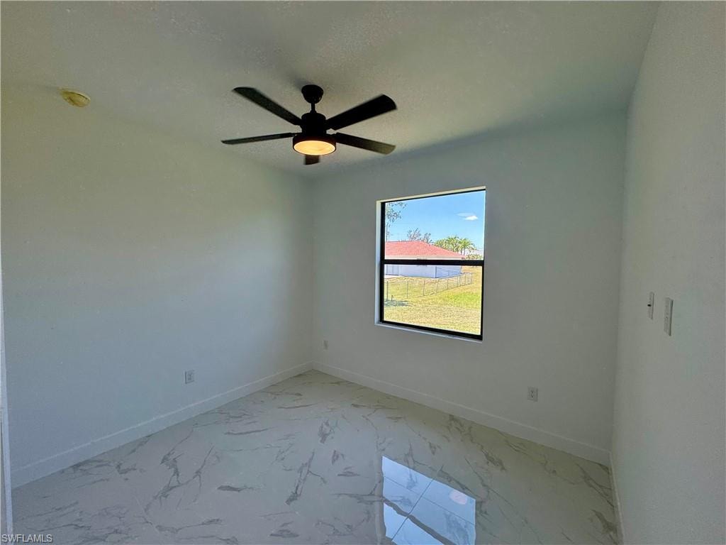 Unfurnished room featuring tile floors and ceiling fan