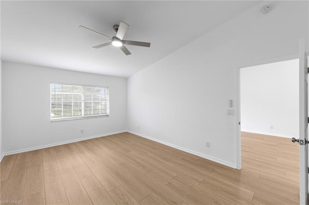 Bright room featuring wood-finish flooring, a window with blinds, a contemporary ceiling fan, and white painted walls