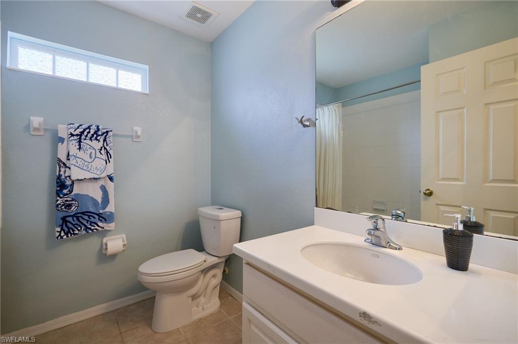Bathroom featuring a single vanity with an integrated sink, polished chrome faucet, and a large wall-mounted mirror