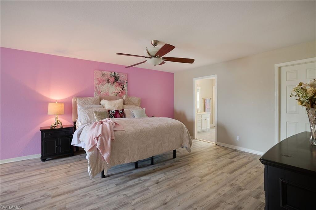 Spacious room featuring wood-finish flooring, a ceiling fan, and a built-in closet with a paneled door