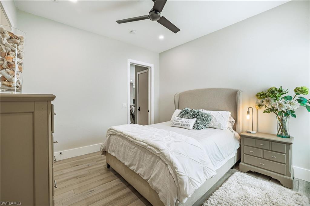 Bedroom featuring wood-finish flooring, a contemporary ceiling fan, recessed lighting, and a white trim package