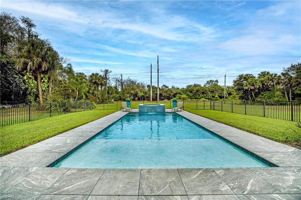 Rectangular swimming pool featuring a light-colored interior finish and a surrounding stone tile deck
