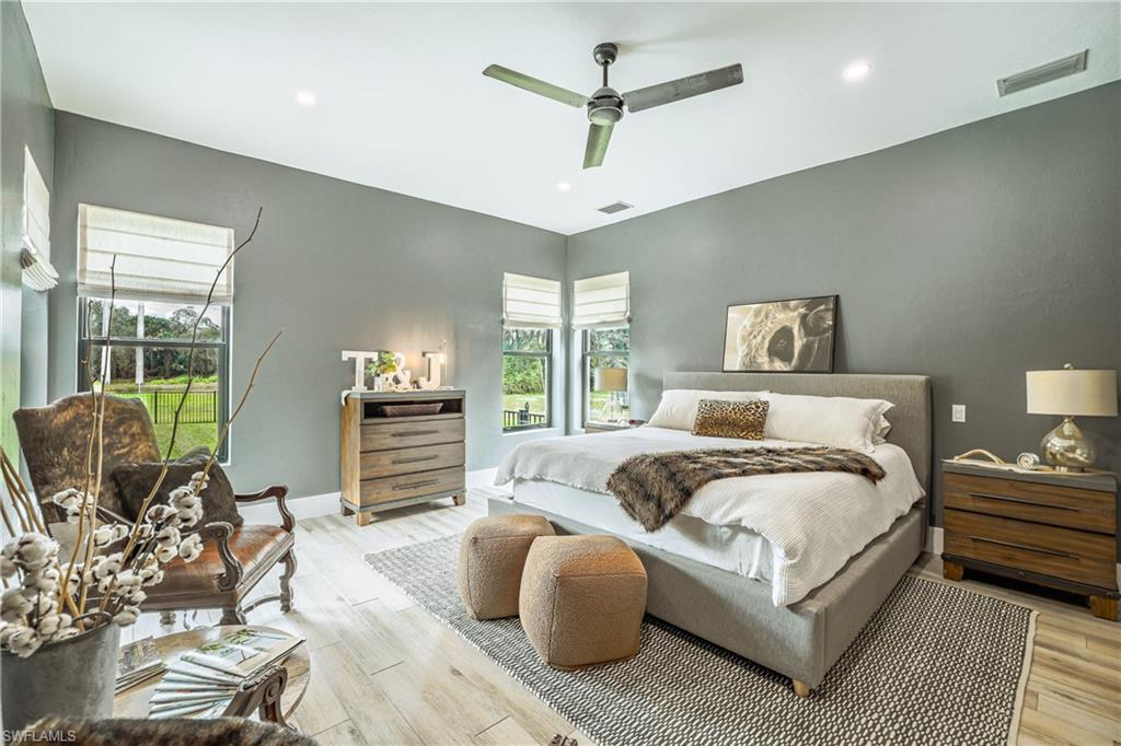 Spacious room with wood-finish flooring, recessed lighting, and a contemporary ceiling fan