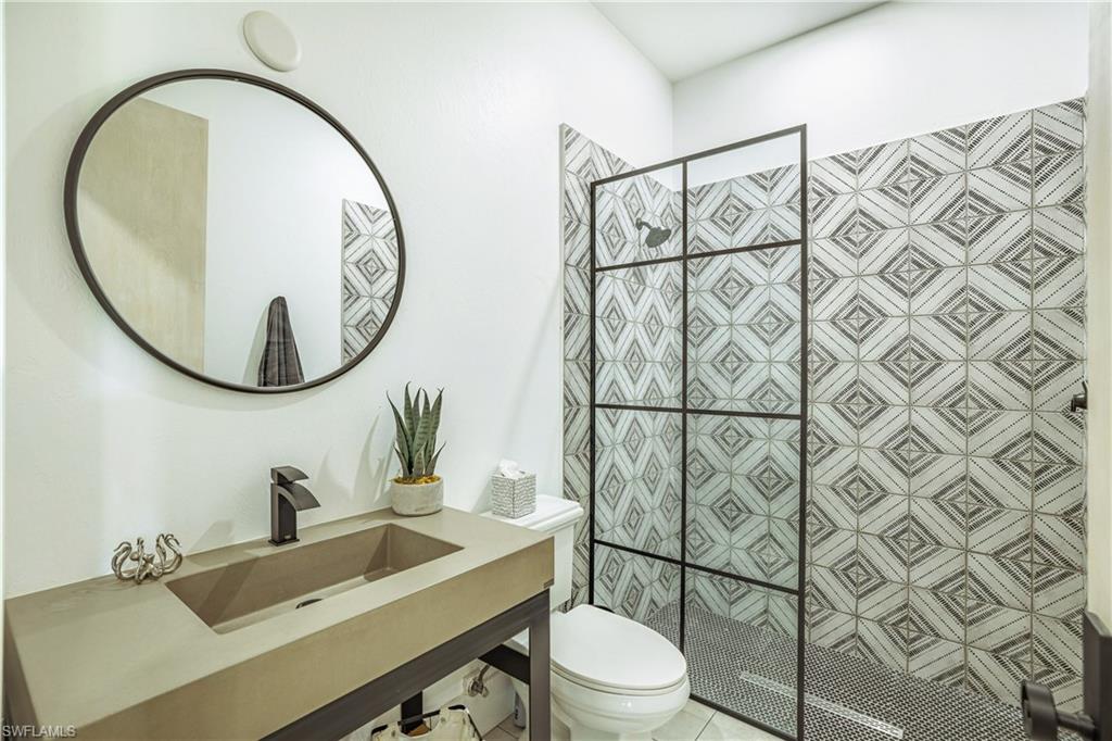 Modern bathroom featuring a concrete-finish vanity with an integrated sink and matte black faucet