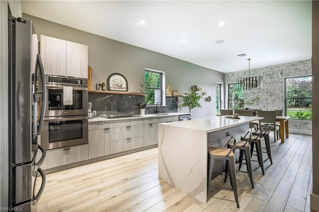 Spacious kitchen and dining area with light wood-finish flooring