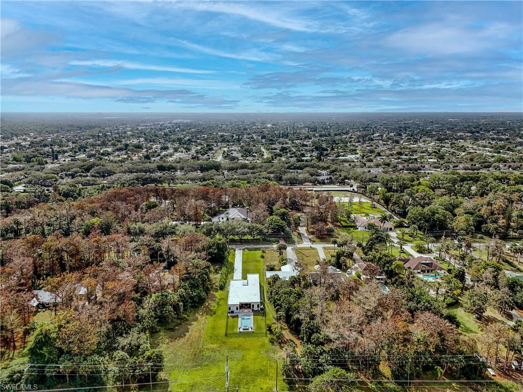 Aerial perspective showcasing a single-story residence with a white exterior and a light-colored roof
