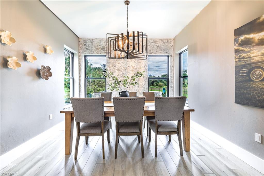 Dining area featuring an accent wall, pendant lighting, and light wood-finish flooring