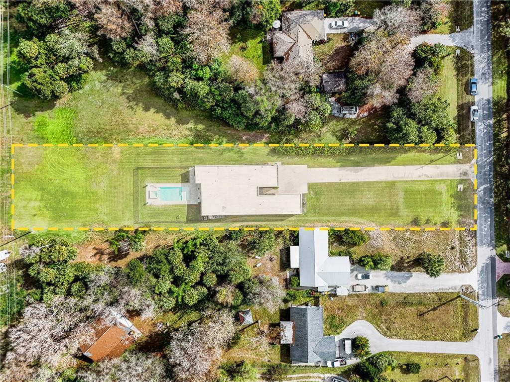 Rectangular property featuring a pool, expansive lawn, and extended driveway