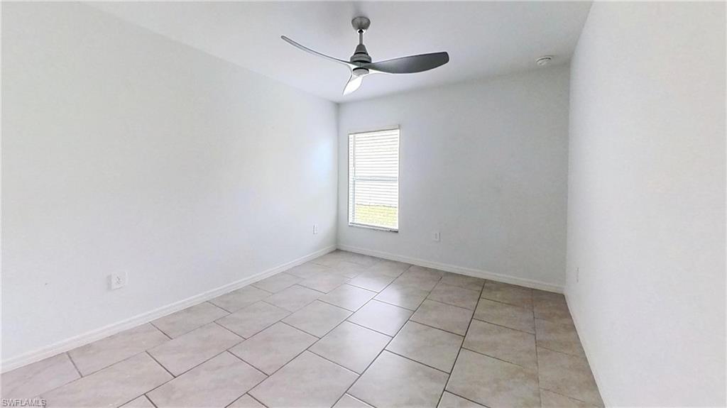 Spacious room featuring neutral tile flooring, a modern ceiling fan, and window blinds