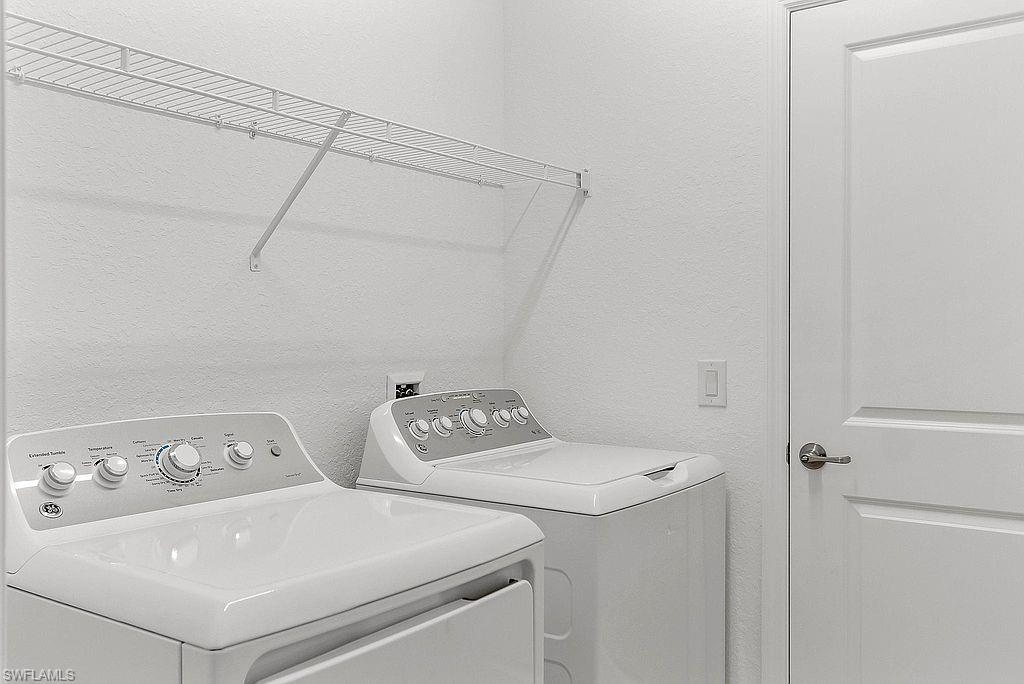 Dedicated utility area featuring white walls and a wire shelving unit