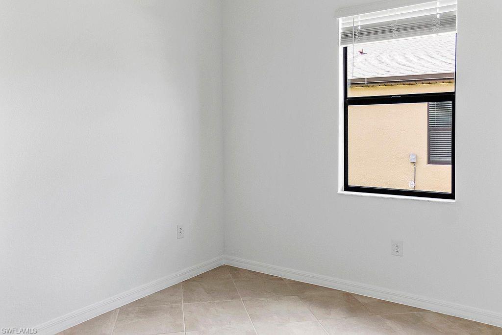 Room featuring neutral white walls and tan tile flooring