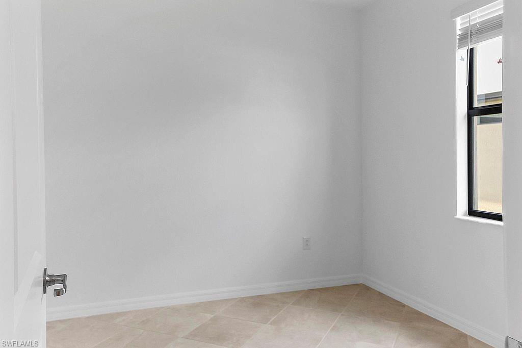 Bright room featuring neutral wall tones, tile flooring, and a window with blinds