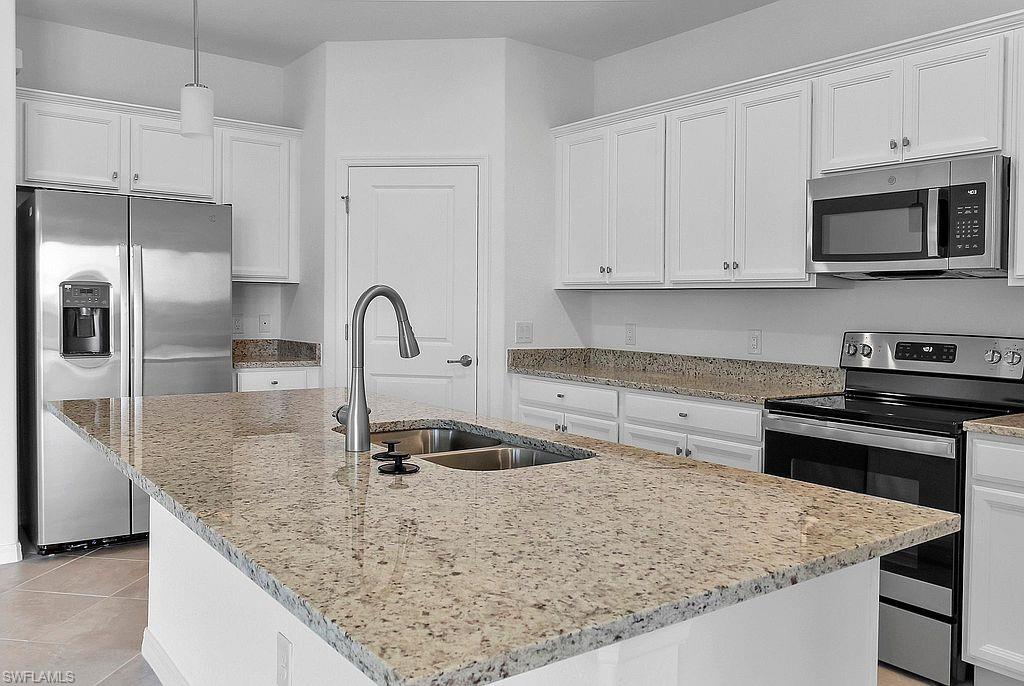 Kitchen island featuring a double basin sink and gooseneck faucet