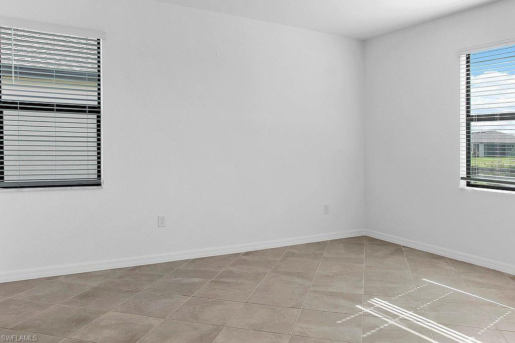Bright interior space featuring white walls and neutral-toned floor tiling