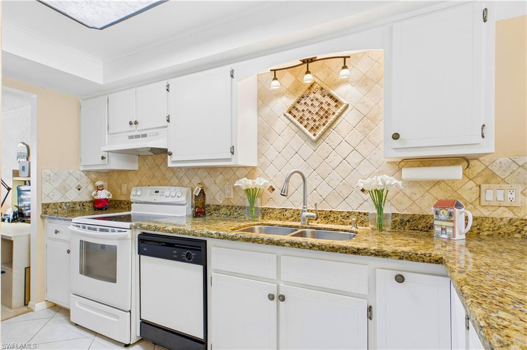 Tiled backsplash and tray ceiling detail give it a polished look
