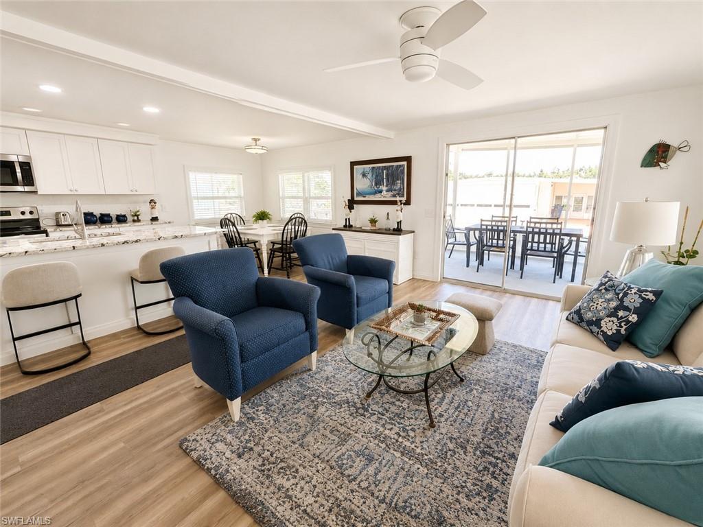 Open-concept living space with wood-finish flooring, recessed lighting, and a ceiling fan