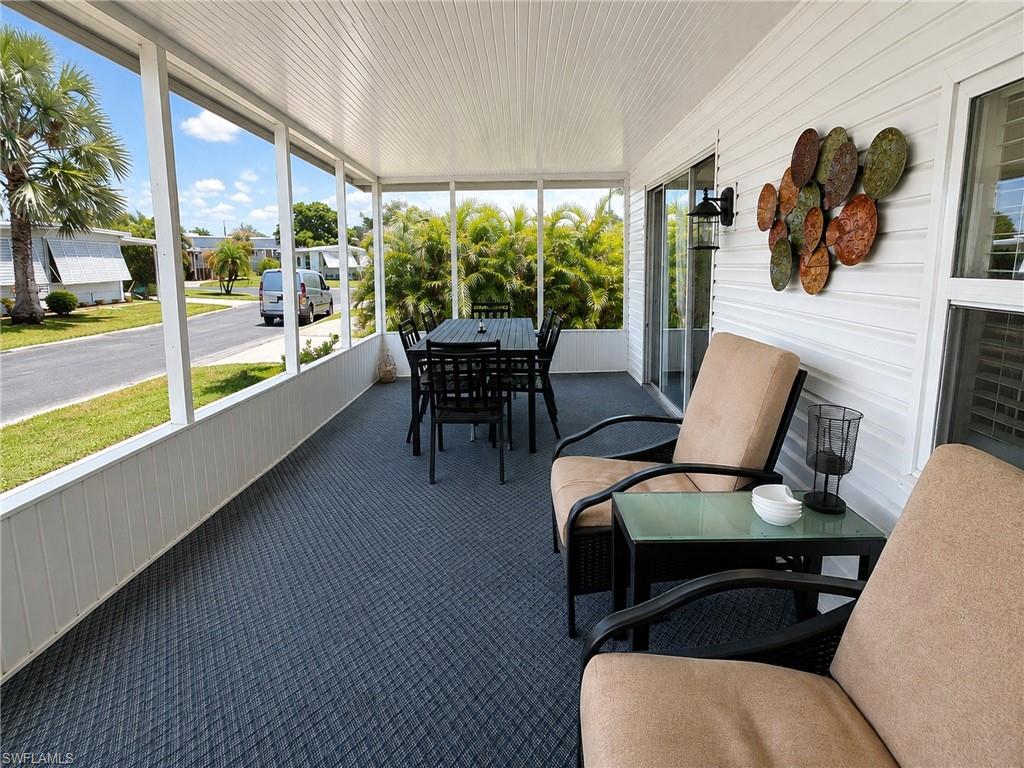 Screened-in porch featuring a textured dark grey floor and white paneled walls