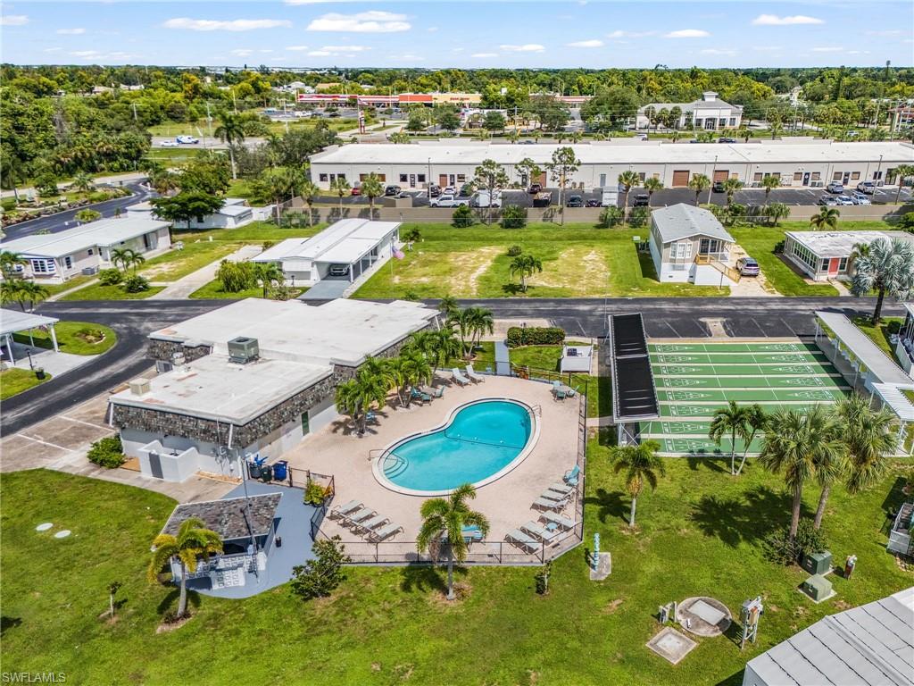 Community amenity area featuring a swimming pool, surrounding lounge deck, and a clubhouse building with stone-finish exterior
