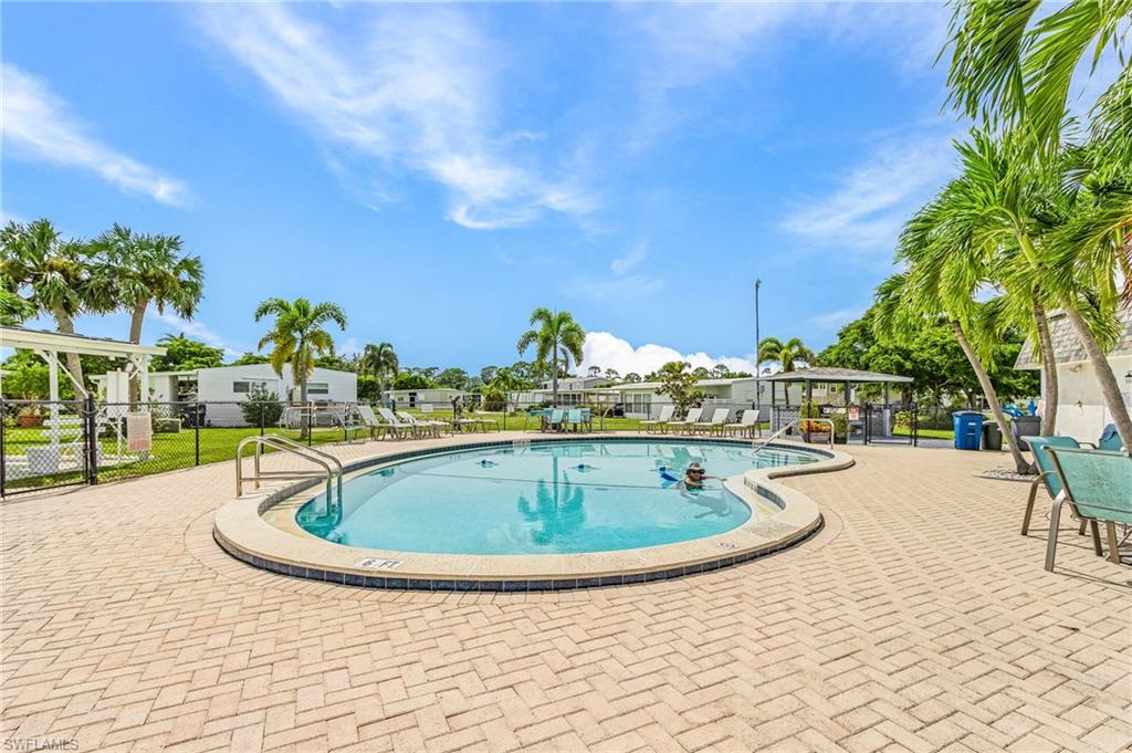 Freeform swimming pool surrounded by a paver patio