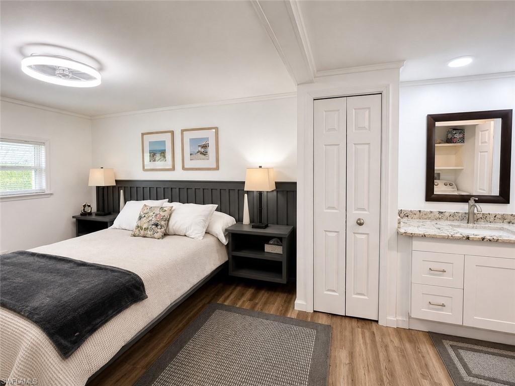 Wood-finish flooring, white walls, and a window with blinds