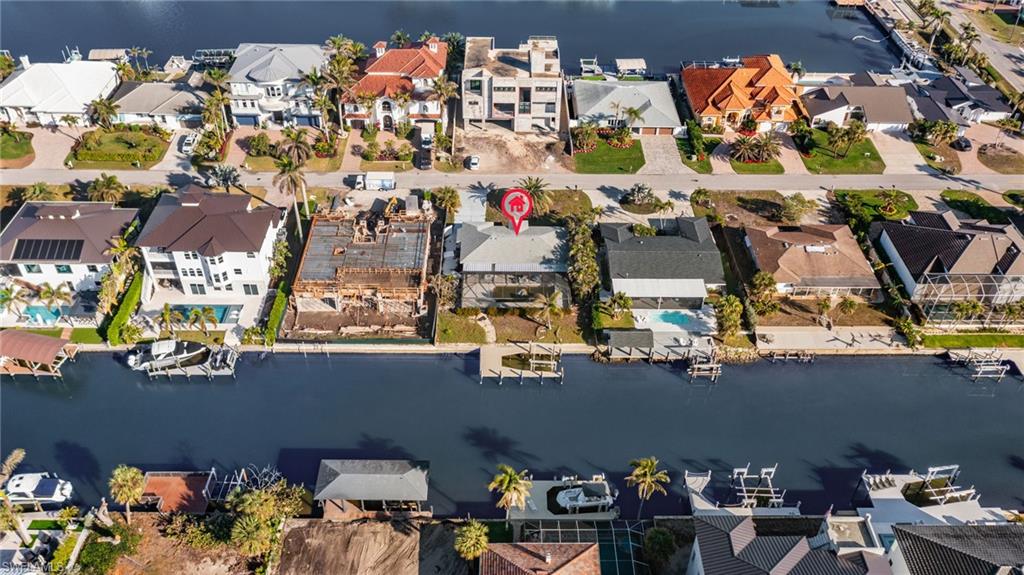 Aerial view of property and surrounding area with a large body of water and nearby suburban area