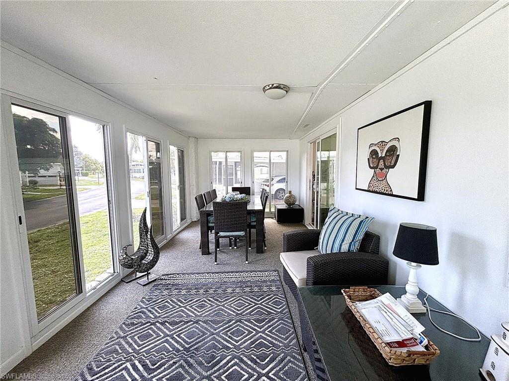 Recessed bed alcove, built-in closet storage, window with blinds, ceiling-mounted light fixture, and carpet flooring