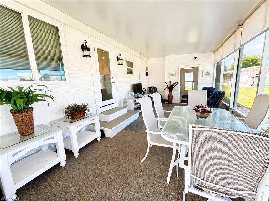 Contemporary kitchen featuring white cabinetry, stainless steel appliances, granite countertops, and vinyl flooring