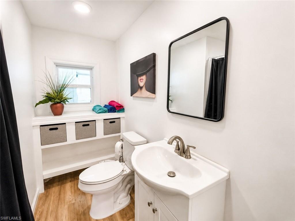Recessed lighting, wood-finish flooring, and a window with blinds