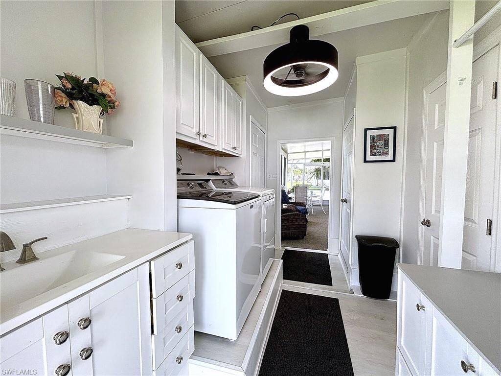Bright utility area featuring white cabinetry, a built-in countertop, and an exterior door with a screen
