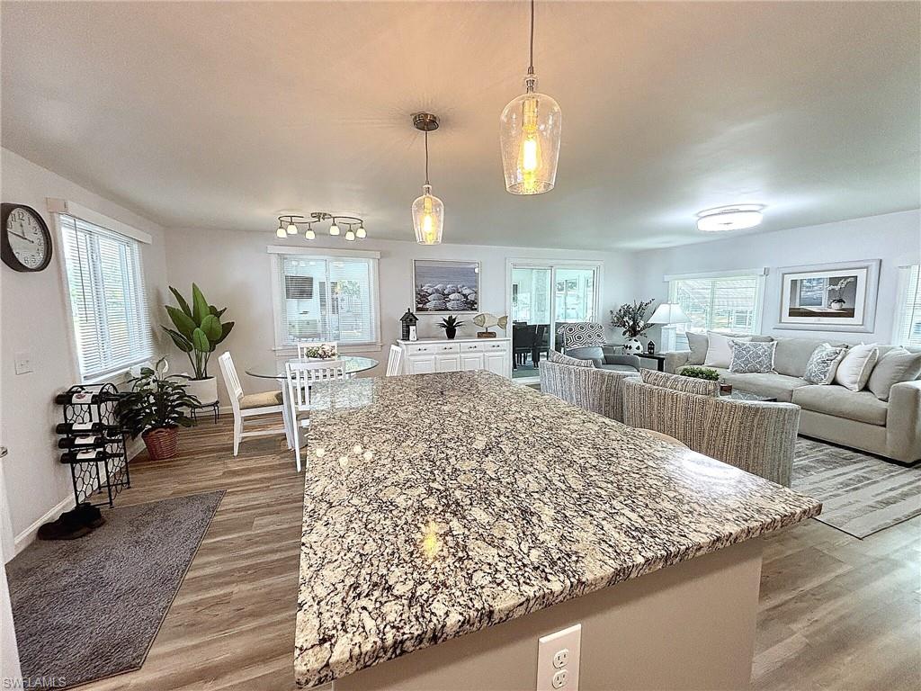 Recessed lighting, wood-finish flooring, white built-in console, and sliding glass doors