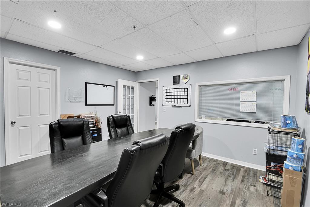 Spacious room featuring a dark wood-finish conference table, wood-finish flooring, and recessed lighting