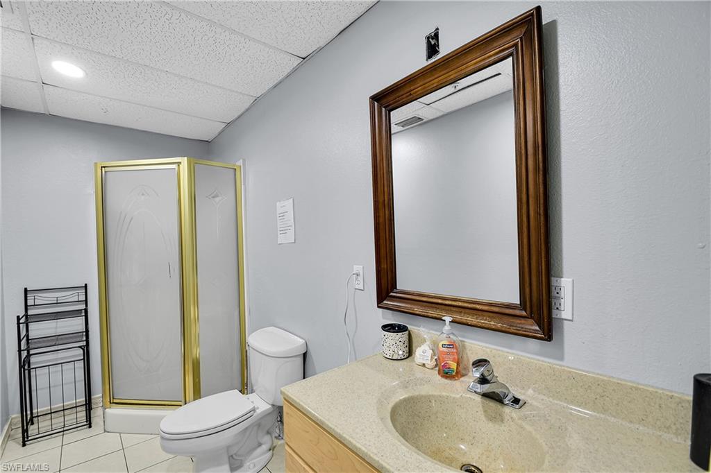 Bathroom featuring a corner shower with a gold-toned frame and frosted glass panels