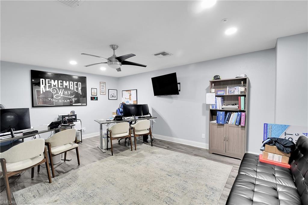 Spacious room featuring wood-finish flooring and light-toned walls