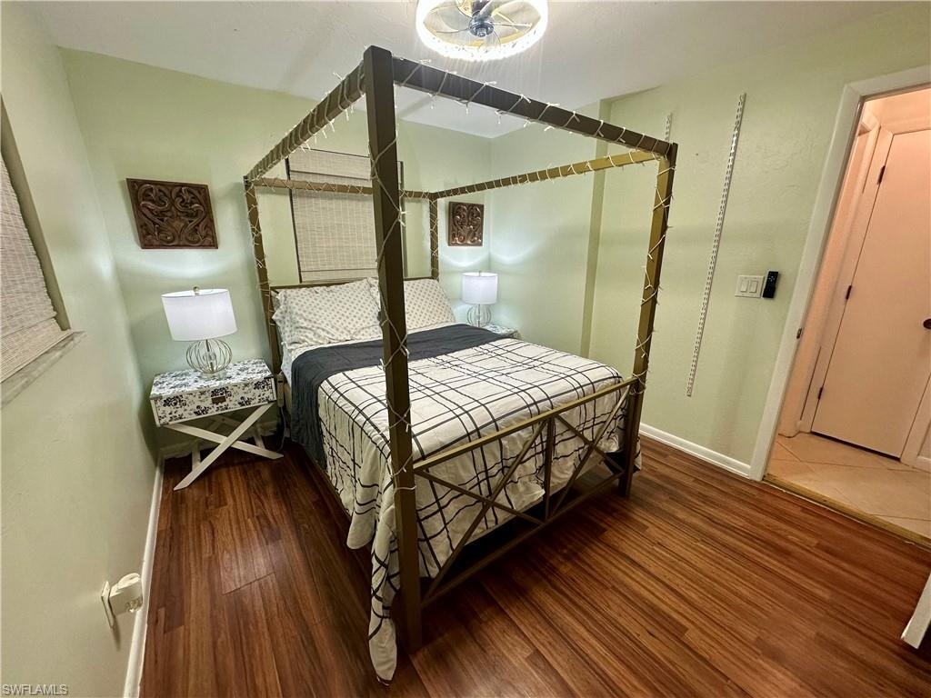 Room featuring wood-finish flooring, light green walls, a ceiling-mounted light fixture, and a solid core door