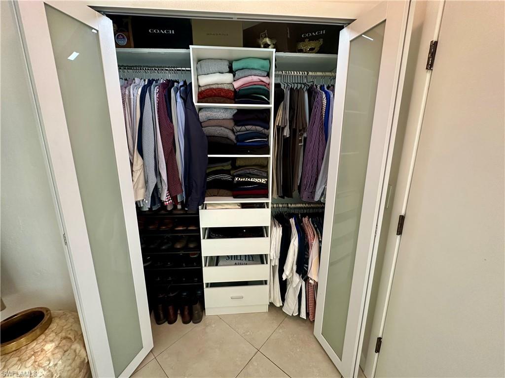 Custom closet system featuring frosted glass bifold doors and integrated shelving