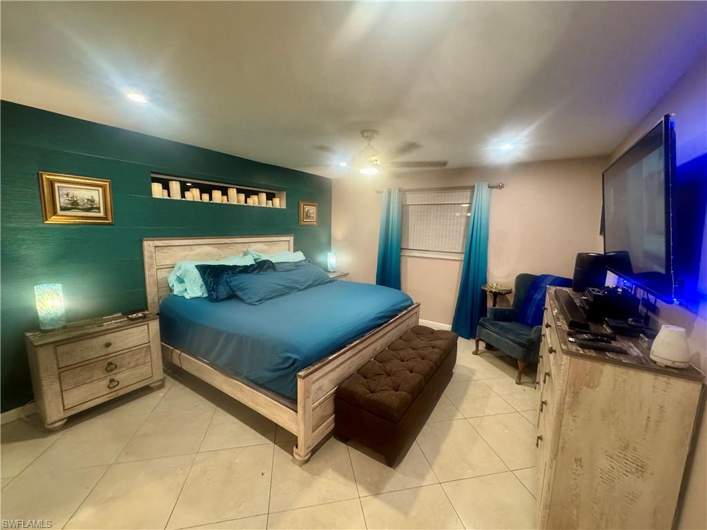 Bedroom featuring tiled flooring and a tray ceiling with recessed lighting