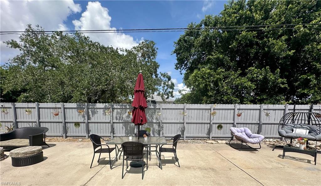 Expansive concrete patio area with a light grey privacy fence