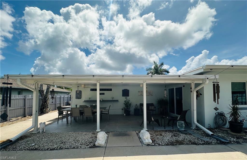 Covered patio area featuring a concrete slab, white aluminum framing, and a rain gutter system