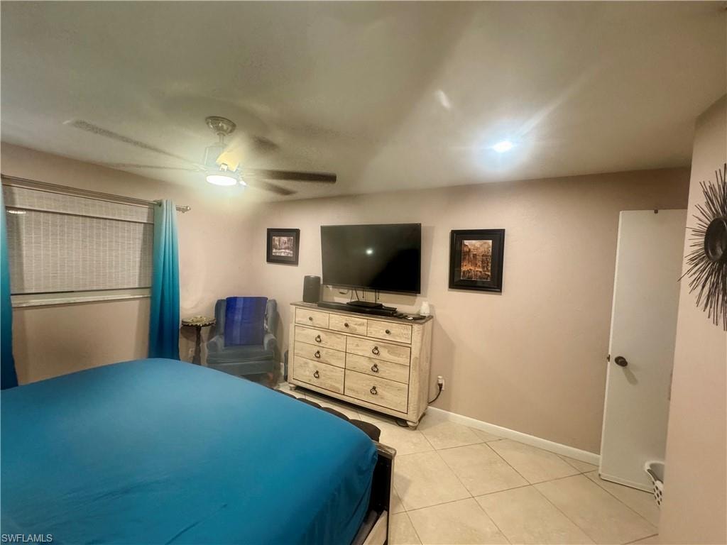 Bedroom featuring a ceiling fan with integrated lighting, recessed lighting, tile flooring, and window treatments with blinds